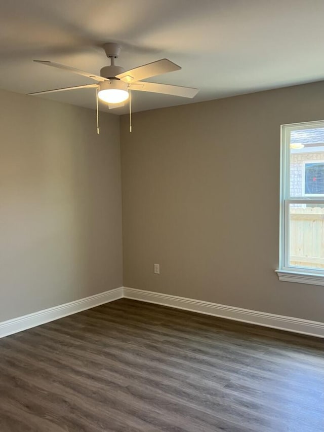 spare room featuring ceiling fan, dark hardwood / wood-style flooring, and a healthy amount of sunlight