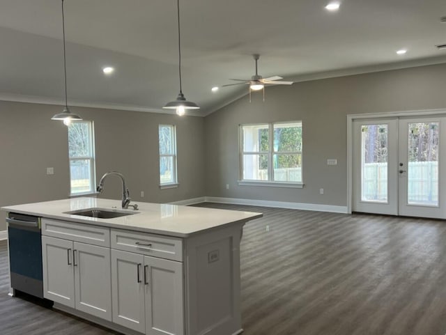 kitchen with white cabinetry, sink, hanging light fixtures, stainless steel dishwasher, and a center island with sink