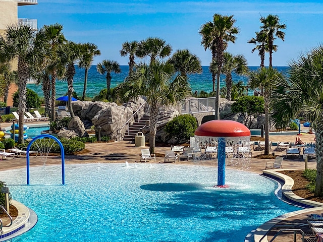 view of swimming pool featuring pool water feature and a water view