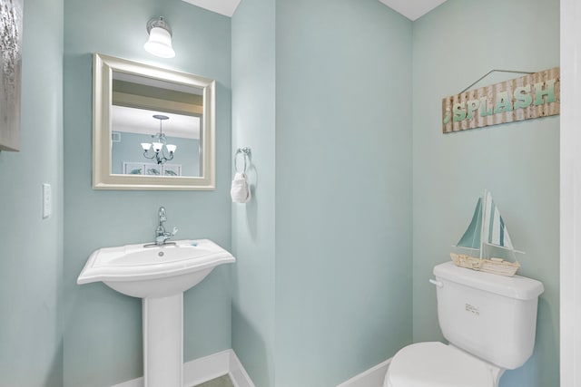 bathroom featuring a chandelier and toilet