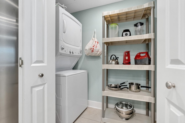 washroom with light tile patterned floors and stacked washer / drying machine