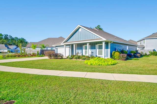 view of front facade featuring covered porch, a garage, and a front yard