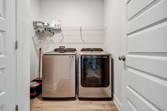 laundry room featuring light hardwood / wood-style floors and washing machine and clothes dryer