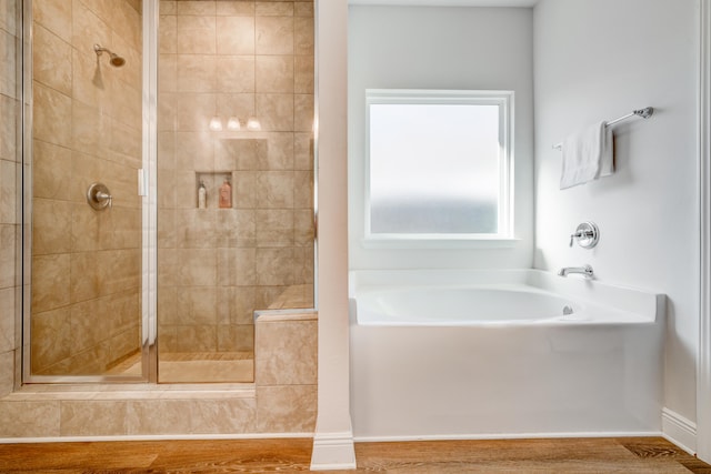 bathroom with hardwood / wood-style flooring and separate shower and tub