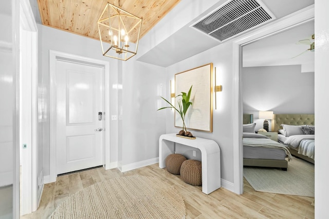 entryway featuring a chandelier, wooden ceiling, and light wood-type flooring