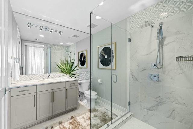 bathroom featuring vanity, toilet, and a shower with door