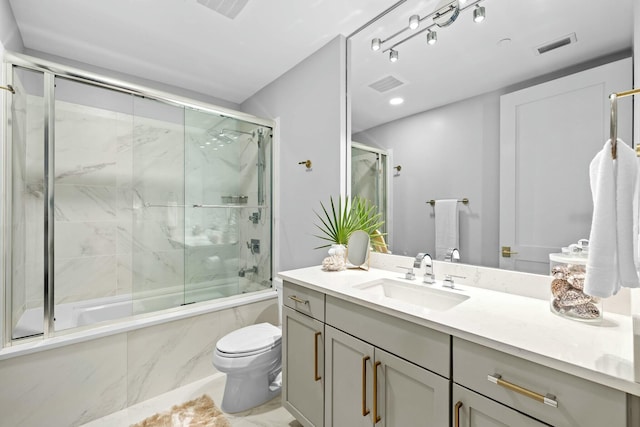 full bathroom featuring toilet, vanity, and combined bath / shower with glass door