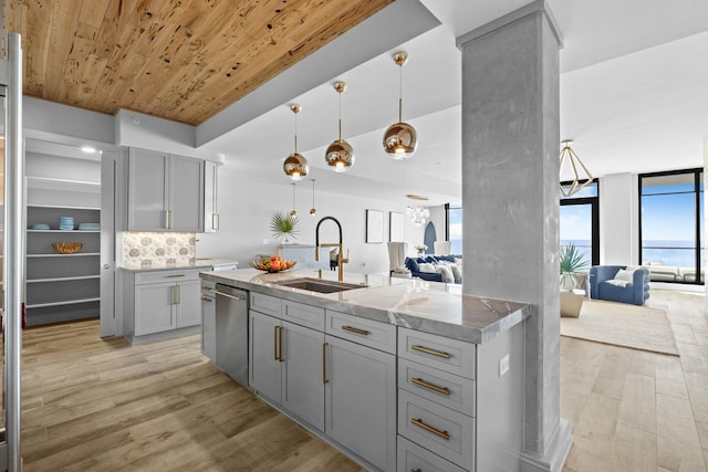 kitchen with gray cabinets, sink, hanging light fixtures, and light wood-type flooring