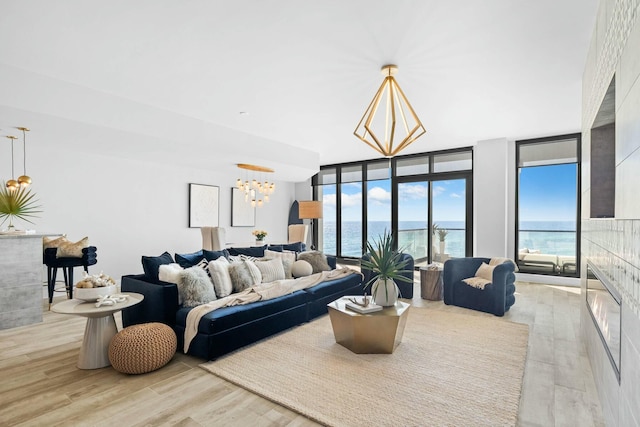 living room with a water view, a healthy amount of sunlight, and a wall of windows