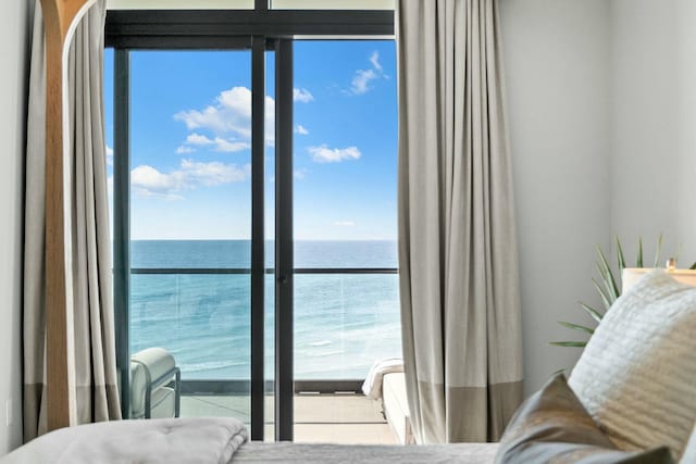 bedroom featuring a water view and multiple windows