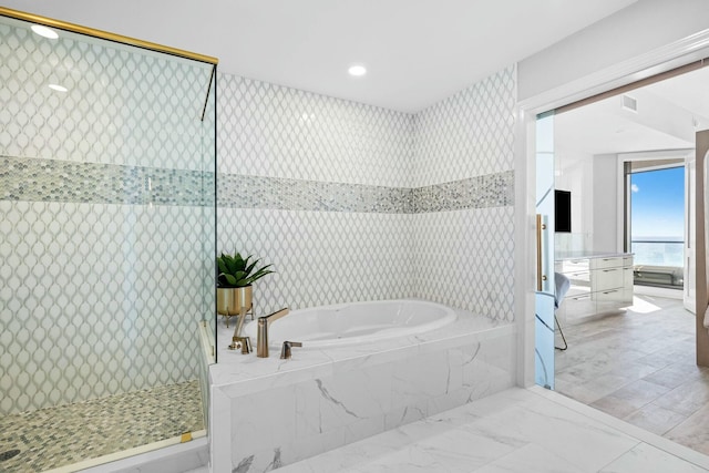 bathroom with a water view and tiled tub