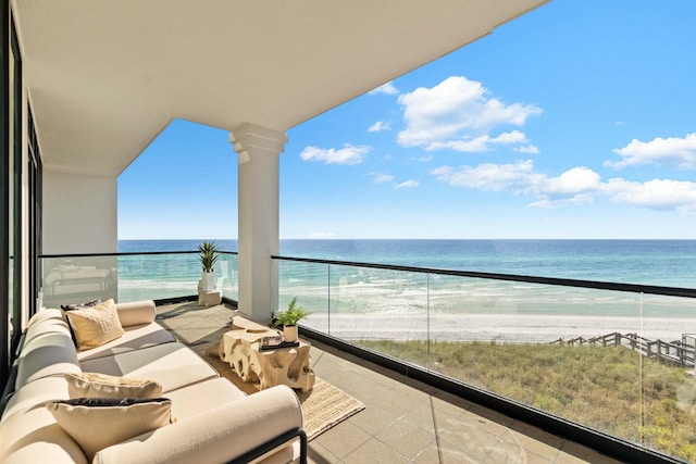 balcony featuring a view of the beach, an outdoor living space, and a water view