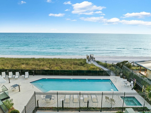 view of pool with a water view and a patio