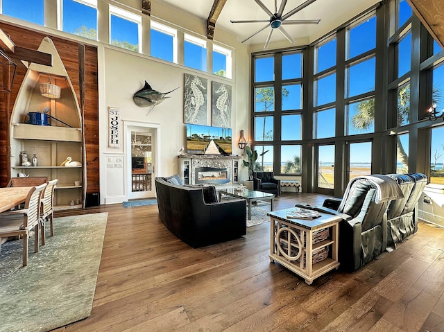 living room featuring a high ceiling, ceiling fan, a wealth of natural light, and hardwood / wood-style floors