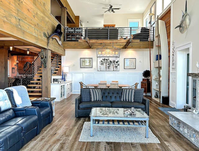 living room featuring ceiling fan, a high ceiling, and hardwood / wood-style flooring