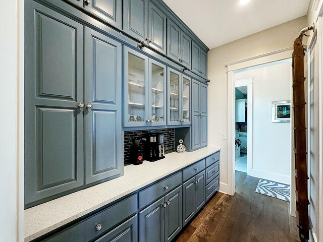 bar featuring backsplash and dark wood-type flooring