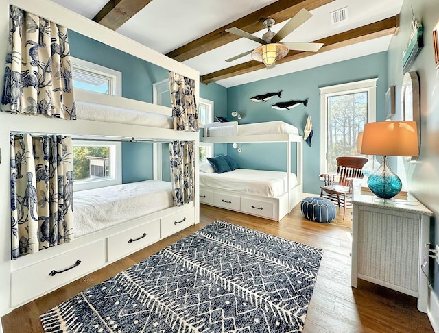 bedroom with hardwood / wood-style flooring, ceiling fan, and beamed ceiling