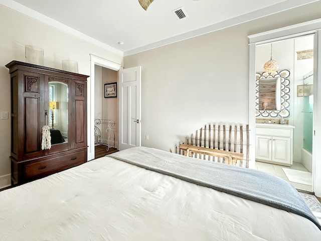 bedroom featuring wood-type flooring, ensuite bathroom, and ornamental molding