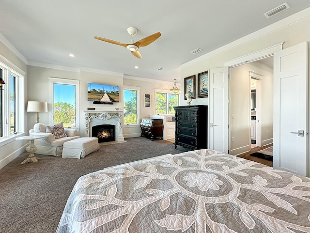 bedroom featuring multiple windows, ceiling fan, crown molding, and a high end fireplace