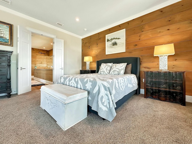 carpeted bedroom featuring ensuite bathroom, crown molding, and wood walls