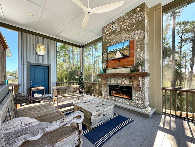 exterior space featuring ceiling fan, a healthy amount of sunlight, and an outdoor stone fireplace