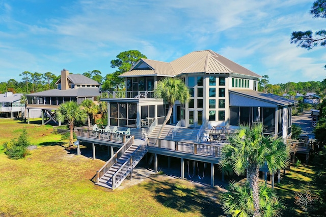 rear view of property with a sunroom and a deck