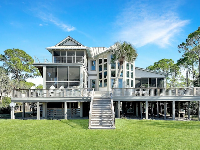 back of house featuring a sunroom, a yard, and a wooden deck