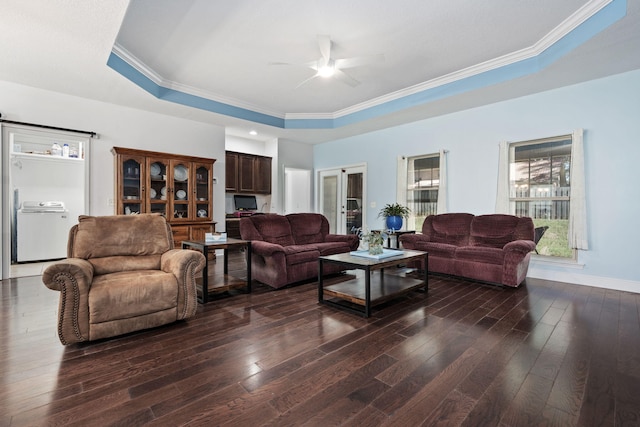 living room featuring a raised ceiling, ceiling fan, dark hardwood / wood-style flooring, and washer / dryer