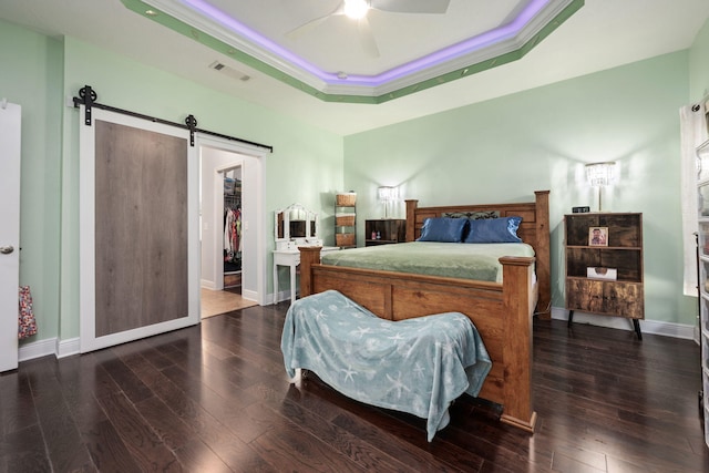 bedroom featuring a barn door, ceiling fan, crown molding, and dark wood-type flooring