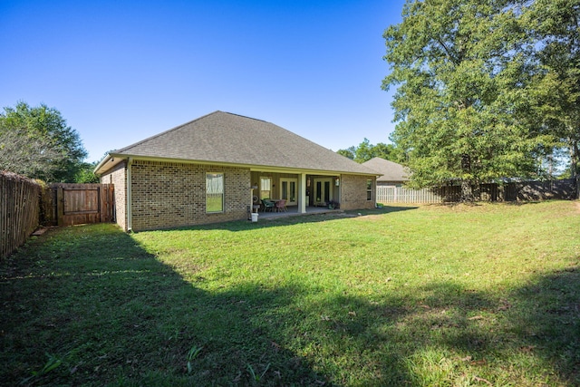 rear view of property with a yard and a patio