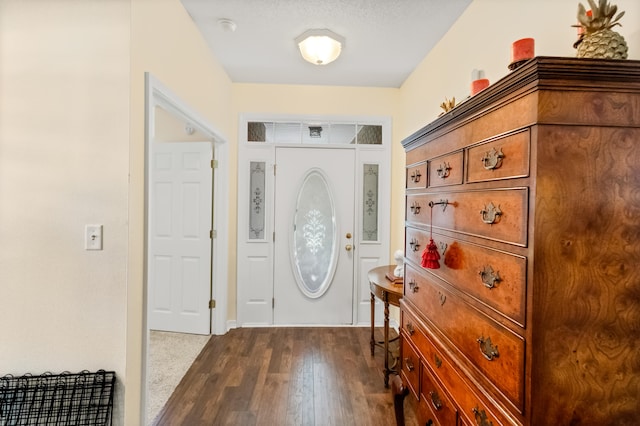 foyer entrance with dark wood-type flooring and a textured ceiling