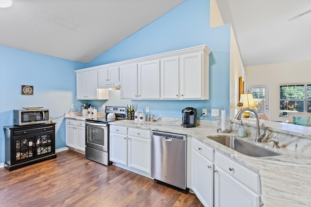 kitchen with appliances with stainless steel finishes, dark hardwood / wood-style floors, white cabinetry, and sink