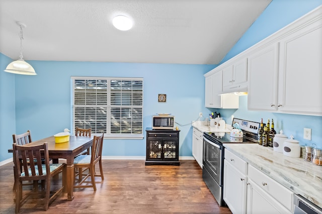 kitchen with dark wood-type flooring, hanging light fixtures, appliances with stainless steel finishes, light stone counters, and white cabinetry