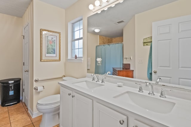 bathroom with toilet, vanity, tile patterned floors, and walk in shower