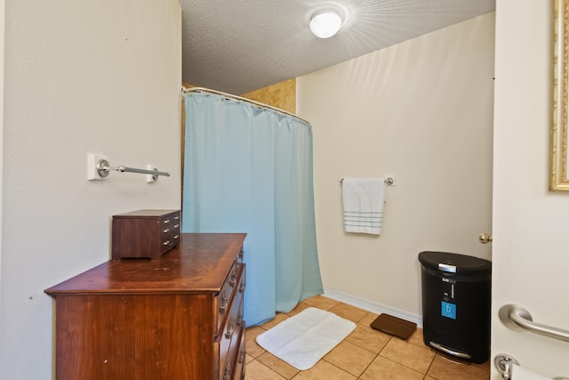 bathroom featuring tile patterned floors, curtained shower, and a textured ceiling