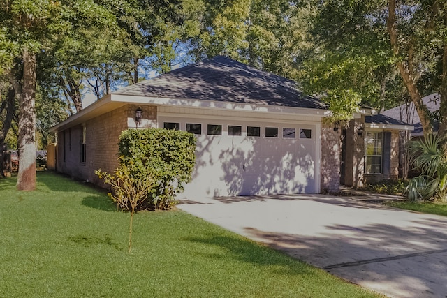 single story home with a garage and a front lawn