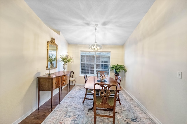 dining space with hardwood / wood-style flooring, a healthy amount of sunlight, and a notable chandelier