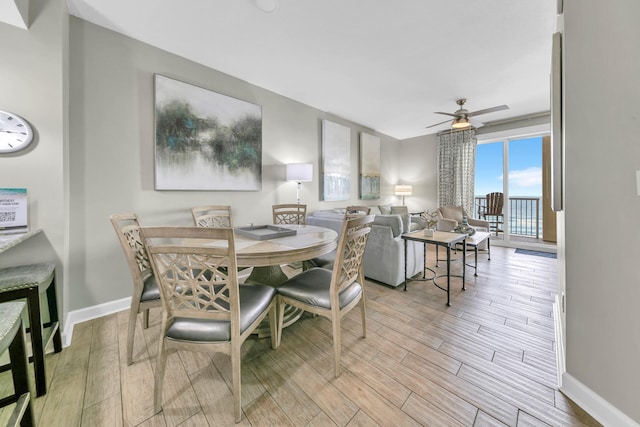 dining space with ceiling fan and light wood-type flooring