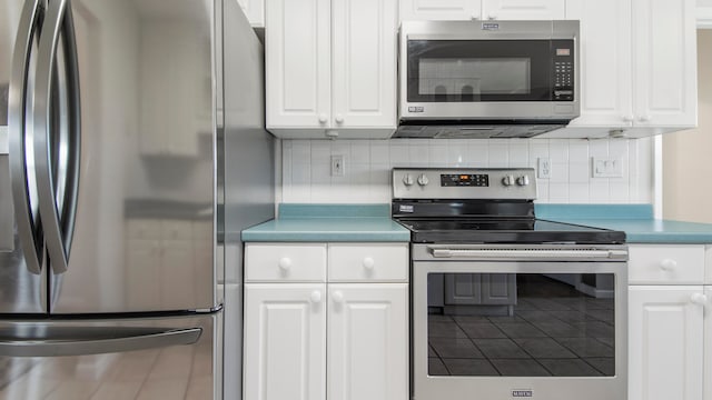 kitchen featuring white cabinets, backsplash, and stainless steel appliances