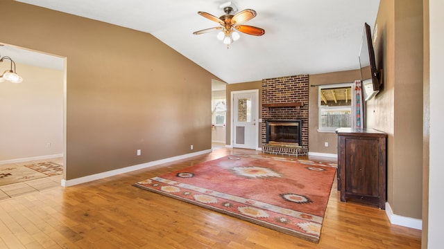 unfurnished living room with a fireplace, hardwood / wood-style flooring, ceiling fan, and lofted ceiling