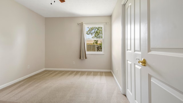 unfurnished room with ceiling fan and light carpet