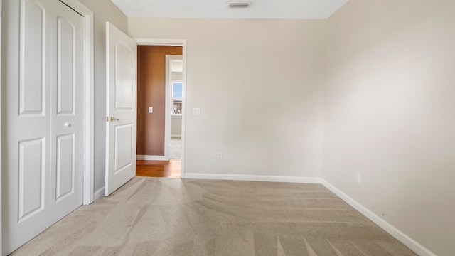 unfurnished bedroom featuring light carpet