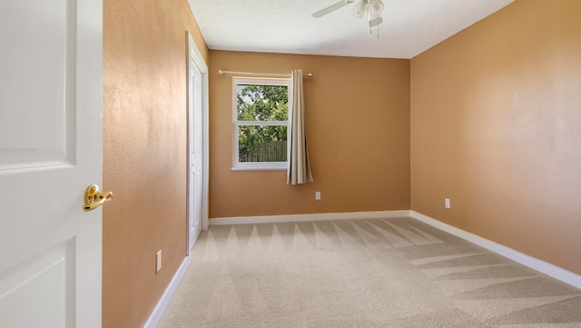 carpeted spare room with ceiling fan