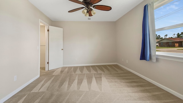 carpeted spare room with ceiling fan