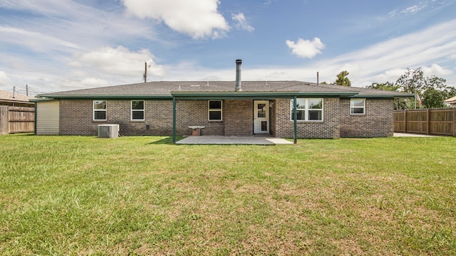 back of house featuring cooling unit, a patio area, and a lawn