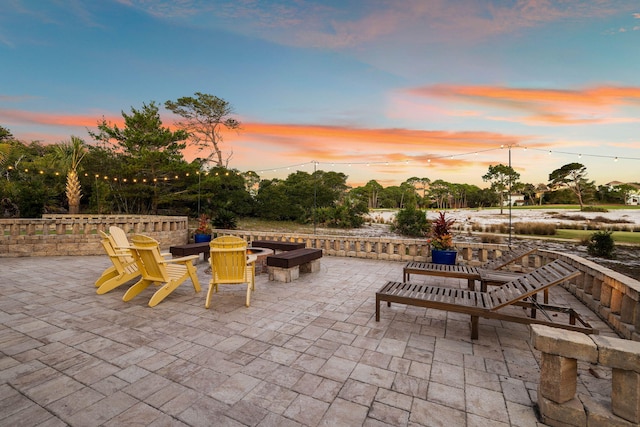 patio terrace at dusk featuring an outdoor fire pit