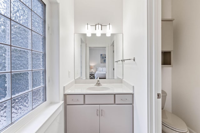 bathroom featuring vanity, toilet, and a healthy amount of sunlight