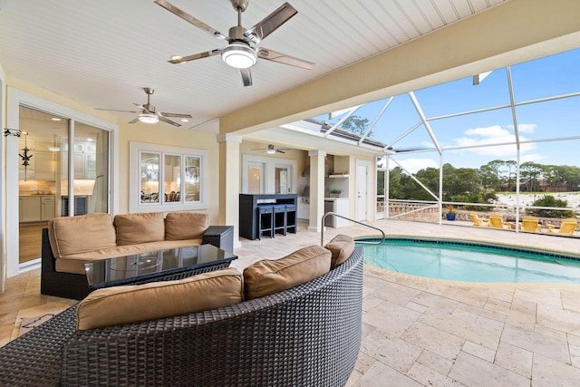 view of pool featuring an outdoor living space, glass enclosure, ceiling fan, and a patio area