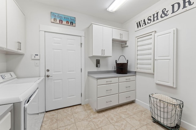 laundry area with washer and clothes dryer, light tile patterned floors, and cabinets