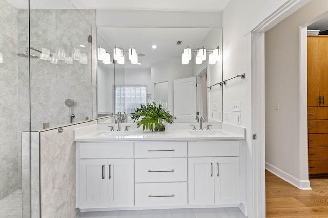 bathroom with wood-type flooring, vanity, and walk in shower